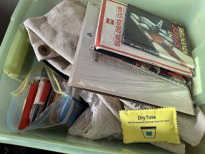 Wisedry 100g rechargeable desiccant pack resting on the edge of a storage tote before the lid is closed for an airtight box check
