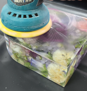 Sanding epoxy resin with dried flowers for a smooth finish