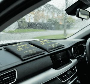 Wisedry car dehumidifier bags on a rainy windshield dashboard