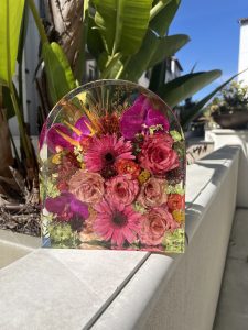 Bright flowers preserved in a clear resin arch by Jordan Kownacki