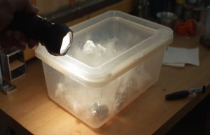 Storage tote with flashlight seal check on a workbench